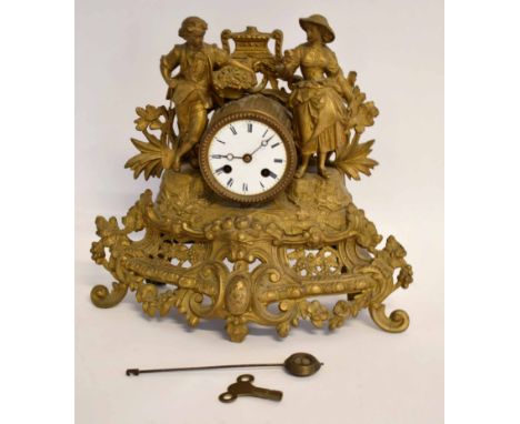 Late 19th century gilt spelter figural mantel clock with drum shaped case surmounted by male and female figures on a pierced 