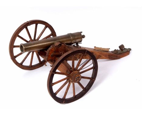 Scale model of field cannon of cast brass construction and mounted on a wooden carriage with steel rimmed wheels, fitted ramr