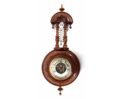 Early 20th century walnut cased aneroid wheel barometer, carved and shaped pediment over a twin-scale mercury glass scale to 