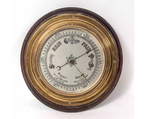 Late 19th century brass cased aneroid barometer with moulded surround to a shaped and stepped lacquered brass case enclosing 