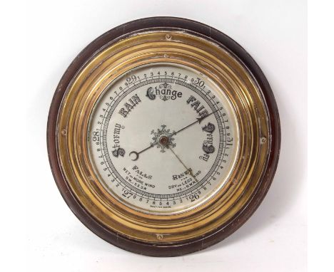 Late 19th century brass cased aneroid barometer with moulded surround to a shaped and stepped lacquered brass case enclosing 