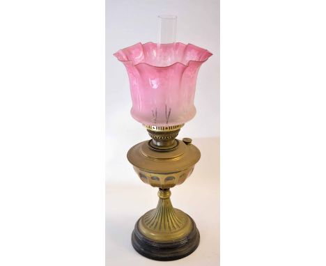 Brass oil lamp on black metal base with pink shade 