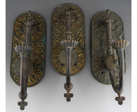 A set of three late 19th century gilt brass and copper wall gas light fittings of Gothic style, rounded rectangular back plat