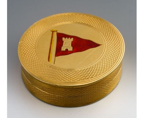 A mid 20th century gold pill box of circular form, engine turned decoration and the pull off cover with central red enamel Is