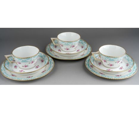 A set of three 19th century KPM Berlin breakfast cups, saucers and tea plates, relief moulded gilt rim and swag border above 