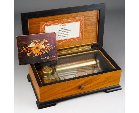 A Rouge Music inlaid cylinder Music Box bears label to lid interior Thorens and 6 airs together with instruction manual. Work