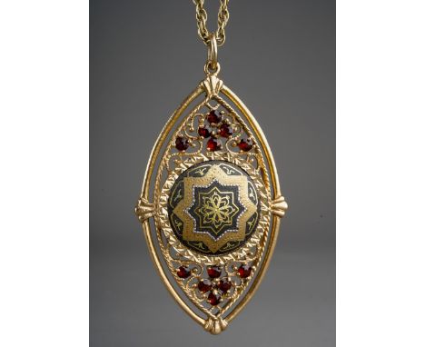 A yellow metal gem set pendant with chain, the pendant set with a central metal panel, with garnet accents suspended from a r