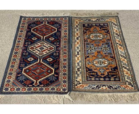 TWO EASTERN WOOLEN RUGS, red, cream and blue ground, the larger with repeat pattern central diamond block, double border, tas