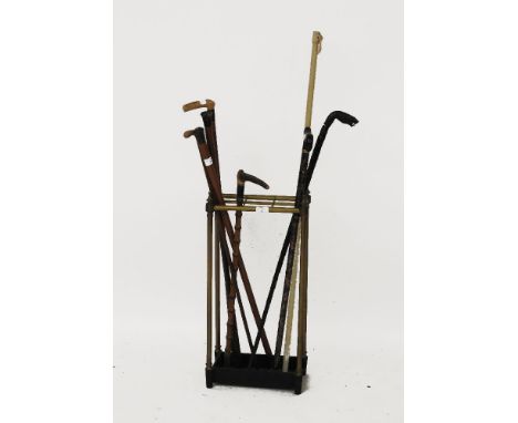 A collection of walking sticks, together with a brass stick stand, 80cm high, bell pull, and cast iron door stop in the form 