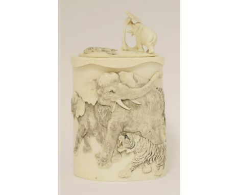 A Japanese ivory box and cover,Meiji period (1868-1912), the raw section of tusk deeply carved in relief with two elephants b