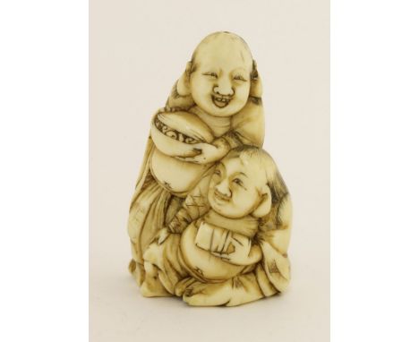 A Japanese ivory netsuke,Meiji period (1868-1912), carved with Hehe Erxian, one seated, the other standing, both holding a bo