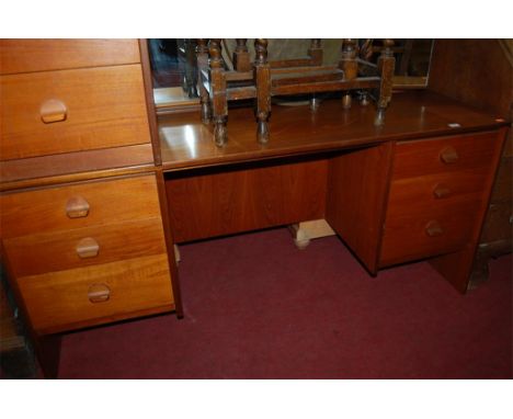 A 1960s English teak two piece bedroom suite comprising; triptych mirror back dressing table and a four drawer bedside chest 