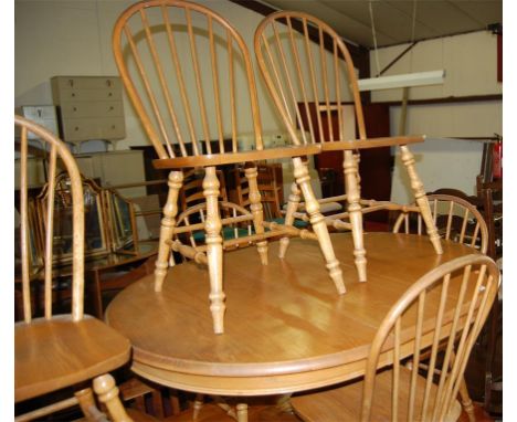 A contemporary light oak extending dining table, having pull-out action and single extra drop-in leaf, together with a set of