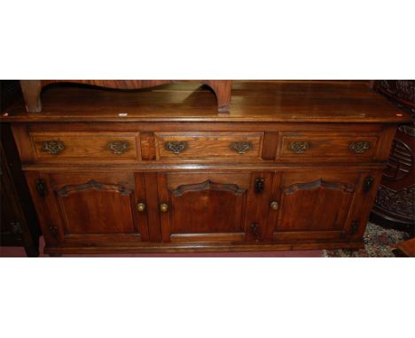 A 17th century style joined oak sideboard, having three frieze drawers over three recessed panel cupboard doors Condition Rep