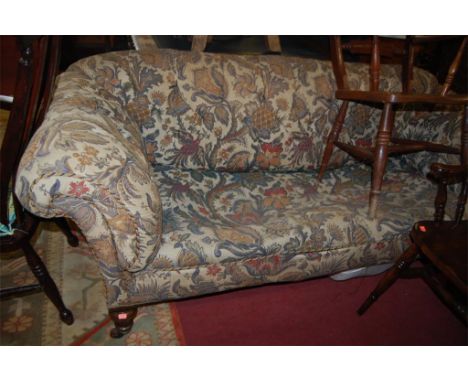 A Victorian mahogany framed and floral upholstered button back three seater Chesterfield raised on turned supports (seat spri