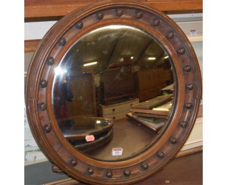A walnut framed convex wall mirror, dia.55cm; a shaped oak framed and bevelled wall mirror; and one other (3) 