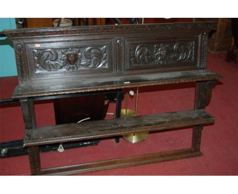 A circa 1900 carved and panelled oak two tier wall shelf