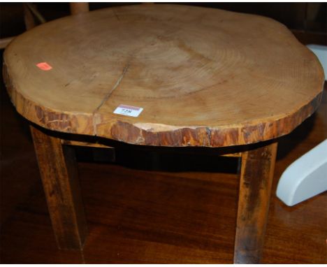 A low occasional table, the top fashioned from a tree trunk segment