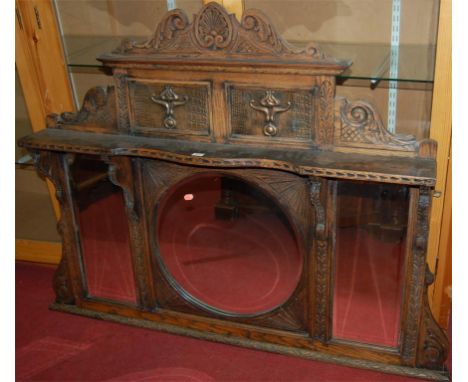 A circa 1900 carved oak and copper inset overmantel mirror, having three bevelled plates 