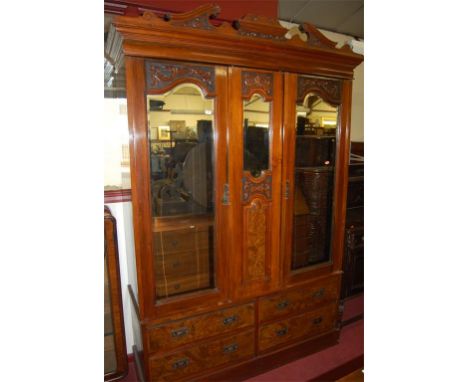 An Edwardian walnut and figured walnut twin mirror door wardrobe, the base fitted with four short drawers
