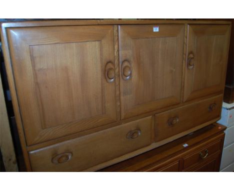 An Ercol blond elm three door sideboard on casters 