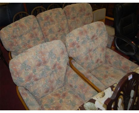 A contemporary Ercol light elm three piece lounge suite comprising; triple sofa and pair of armchairs each with floral uphols