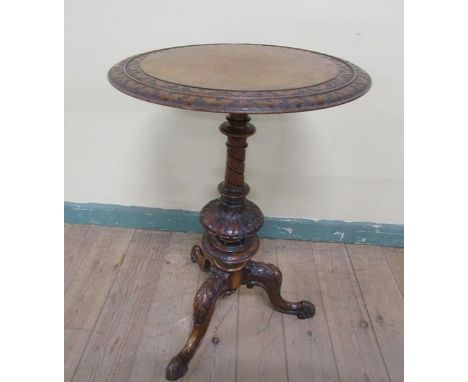 A Victorian walnut circular pedestal tripod table, the top with two outer carved bands of scrollwork on a writhen ring turned