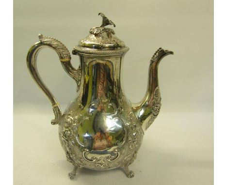 A Victorian silver coffee pot embossed and chased with panels of flowers and with open scroll bordered cartouche, the hinge d