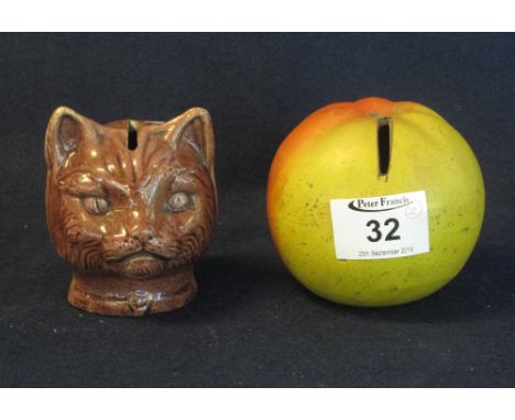 Two ceramic money boxes, one in the form of an apple, the other a cat's head. (2)(B.P. 24% incl. VAT)