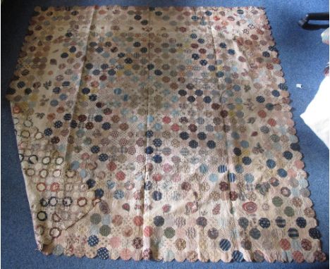 A probably early 19th Century patchwork quilt made from small hexagons of printed cotton with paper to centre of each patch t