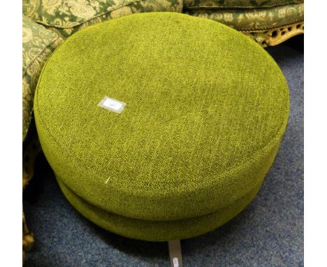 A DFS green upholstered circular pouffe or footstool with white metal legs