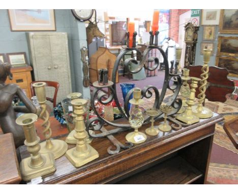 Good collection of brass candlesticks together with a wrought iron candelabra 