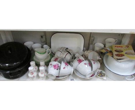 A shelf of assorted teaware, enamel roasting pans etc