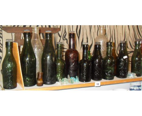 Shelf of old glass bottles with embossed brewery names (mainly West Country) associated book