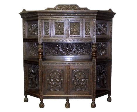 A Victorian oak cupboard, in the 17th century style, the leaf carved cornice over a central cabinet, flanked by a canted open