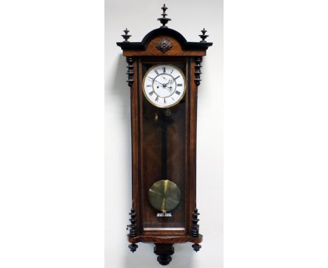 A late 19th century walnut and ebonised twin weight Vienna style wall clock, the 6 ½ inch white enamel dial with centred subs