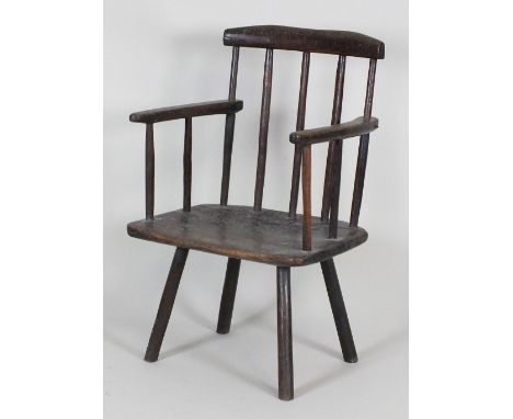 An early 19th century oak primitive armchair, the bar back on five stick supports, the open arms on slender supports above a 