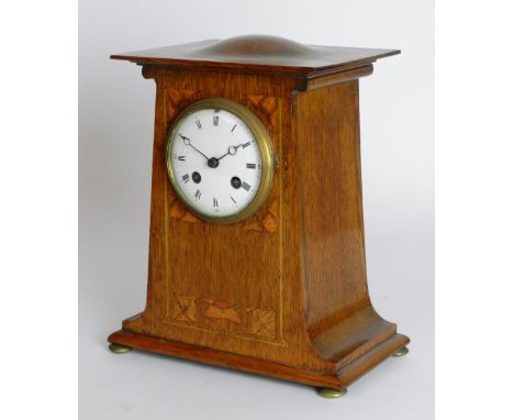 An oak Art Nouveau mantel clock, convex enamel dial with ring of Roman numerals, the tapering case inlaid with stylised flowe
