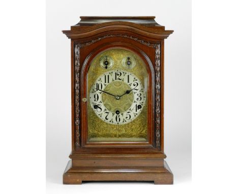 An early 20th century mahogany bracket style chiming mantel clock, the 6 inch arched dial with chapter ring of Arabic numeral