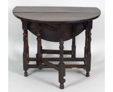 An early 18th century oak gate-leg breakfast table, the oval top above a single end frieze drawer on eight slender turned sup