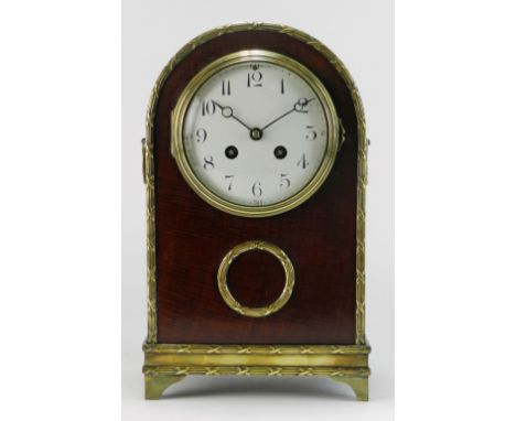 A 19th century French Empire style mahogany arched mantel clock, the 4½ inch enamel dial with ring of Arabic numerals and twi