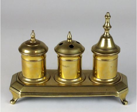a late 18th/early 19th century brass ink standish, with ink pot, sander and wafer pot on a rectangular canted base and four s