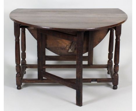 A late 17th / early 18th century oak gate-leg dining table, the oval top over a single end frieze drawer on turned corner sup