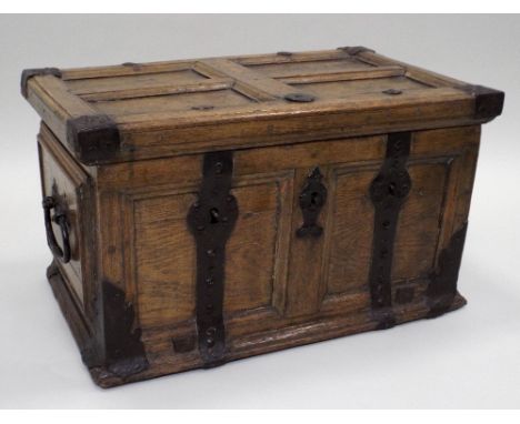 A 17th century continental joined oak strong box, the four panel hinge lid with interior strap iron hinges, over a two panel 
