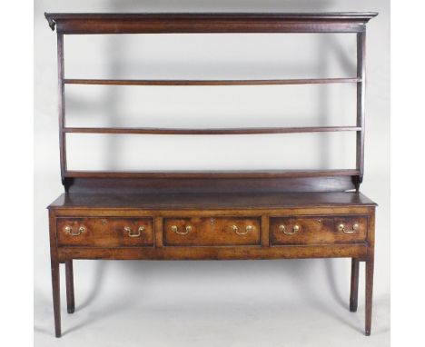 A George III oak high dresser, the three shelf open rack on a three drawer base fitted with brass swan neck handles, raised o