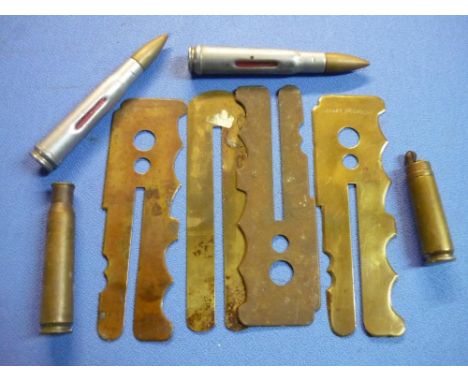 Four brass British military button cleaning slides, one stamped with WD broad arrow mark 1955, two drill rounds, trench art t