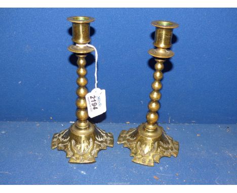 A pair of 19th century cast brass Arts and Crafts religious candlesticks with graduated bobbin stem, 7 1/2" tall.