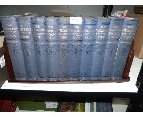 Ten volumes of The Children's Encyclopedia on a Bakelite book stand.