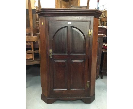 George III oak corner cupboard with ached panelled door enclosing three shaped shelves on bracket feet 117 cm high, 79 cm wid