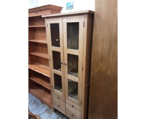 Good quality contemporary light oak bookcase with shelved interior enclosed by two glazed doors, with four drawers below, 80c